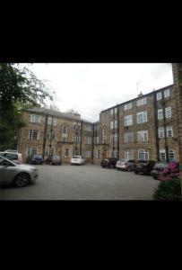 a parking lot in front of a large brick building at Linnet House - Relaxing - Leafy - Bright 2 Bedroom Apt in Liverpool