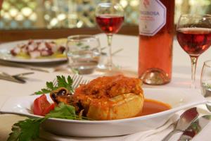 a plate of food on a table with wine glasses at Hotel Portonuovo in Vieste