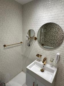 a white bathroom with a sink and a mirror at Midtown Nile View Suites in Cairo