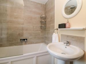 a bathroom with a sink and a tub and a mirror at Dale View Cottage in Bakewell +16 photos