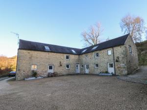 a large brick building with white doors and windows at Dale View Cottage in Bakewell