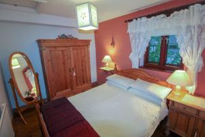 a bedroom with a bed and a dresser and a mirror at The Granary Ruthwaite in Uldale