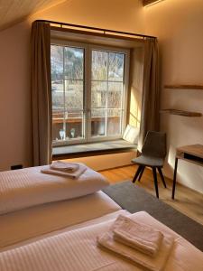 una camera da letto con un letto, una finestra e una sedia di das MARX - Gasthof Marx - Apartments a Grosskirchheim