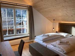 una camera da letto con due letti e una grande finestra di das MARX - Gasthof Marx - Apartments a Grosskirchheim