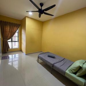 a room with a ceiling fan and a bed in it at D` Totok HouseStay in Sepang