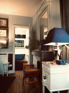 un soggiorno con tavolo e vasca blu di Manoir du Clap a La Cerlangue