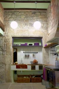 cocina con fregadero y pared de piedra en Lera de cal roger, en Verdú