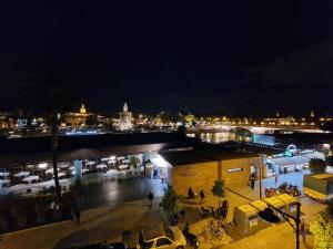 Una ciudad de noche con coches estacionados en un estacionamiento en Betis del Oro en Sevilla
