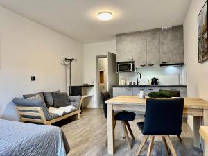 Vista apartment 04 في روكيتنسي ناد جيزيرو: مطبخ وغرفة معيشة مع طاولة وأريكة