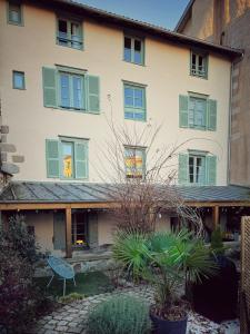 un grand bâtiment avec volets verts dans l'établissement Maison d'hôte Les Allois, à Limoges