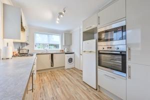 a kitchen with white appliances and a wooden floor at Superb Sandbanks Apartment near Beach and Bars with Free Parking in Poole