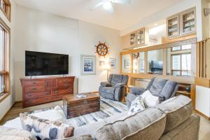 a living room with two couches and a flat screen tv at Lakefront Tofte Townhome with Deck and Views! in Tofte