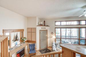 ein Wohnzimmer mit einem Kamin und einem Tisch in der Unterkunft Lakefront Tofte Townhome with Deck and Views! in Tofte