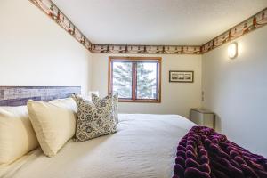 a bedroom with a bed with pillows and a window at Lakefront Tofte Townhome with Deck and Views! in Tofte