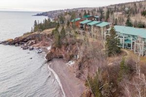 a house on a cliff next to the water at Lakefront Tofte Townhome with Deck and Views! in Tofte