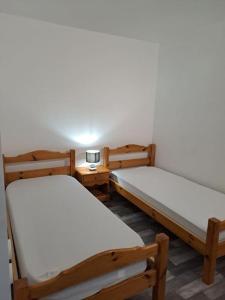 a room with two beds and a table with a lamp at Appartement résidence Les Dryades in Gérardmer