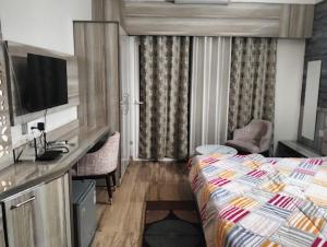 a hotel room with a bed and a desk at Hotel Moonlite in Greater Noida