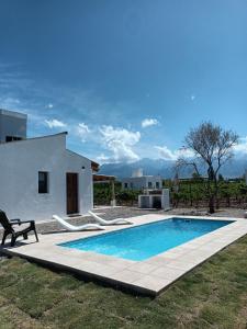 a villa with a swimming pool in front of a house at Finca Rosablanca in Tunuyán