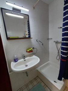een badkamer met een wastafel, een bad en een spiegel bij Waldfee in Altenau