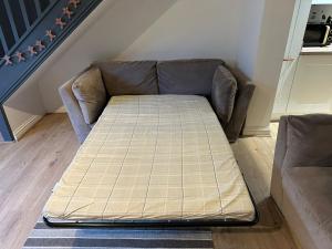 een bed op een bank in een woonkamer bij Cotswold's Large 4 bed house-Sleeps 10-Free Parking-Wifi 