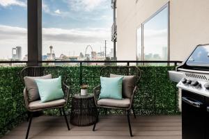 a balcony with two chairs and a grill on a building at Gameday Oasis - Private Balcony - Jefferson Park - Tesoro in Denver