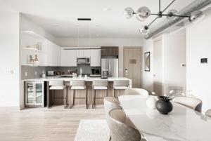 a white kitchen with a table and chairs at Luxurious Escape - Walk to Empower Field - Tesoro in Denver