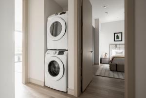 a laundry room with a washer and dryer next to a bed at Luxurious Escape - Walk to Empower Field - Tesoro in Denver
