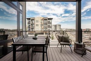 a table and chairs on a balcony with a view at Luxurious Escape - Walk to Empower Field - Tesoro in Denver