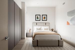 a bedroom with a large bed in a white room at Luxurious Escape - Walk to Empower Field - Tesoro in Denver