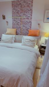 パリにあるCozy Paris Apartmentのレンガの壁の客室で、大型ベッド1台を利用できます。
