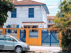 um carro estacionado em frente a uma cerca com uma casa em HOSTEL DA VILA em Santos