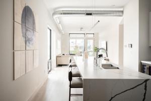 a white kitchen with a large island in the middle at Contemporary Condo - Grill - Balcony - Tesoro in Denver
