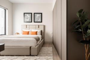 um quarto com uma cama com almofadas laranja em Brand New Condo - Walk to Empower Stadium - Tesoro em Denver