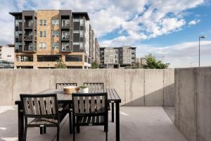 einen Tisch und Stühle auf einem Dach mit Gebäuden in der Unterkunft Brand New Condo - Walk to Empower Stadium - Tesoro in Denver