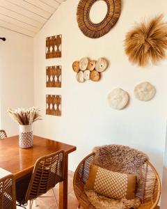uma sala de jantar com uma mesa e cadeiras e pratos na parede em Casinhas Fim do Mundo em Reguengo Grande
