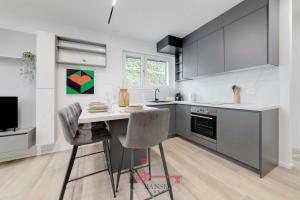 una cucina con tavolo e sedie in una stanza di Home Sofia Room 2 - Modern Station -By EasyLife Swiss a Lugano