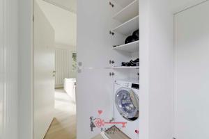 a laundry room with white walls and a washing machine at {Home Sofia} Room 2 - Modern Station in Lugano