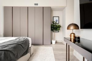 a bedroom with a bed and a table with a lamp at Contemporary Condo - Grill - Balcony - Tesoro in Denver