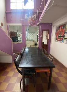 uma sala de jantar com uma mesa e paredes roxas em Casa a una cuadra de costanera Gualeguaychu Hasta 8 personas em Gualeguaychú