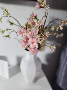 un vaso bianco pieno di fiori rosa su un tavolo di City Hotel - Doppelzimmer a Rastatt