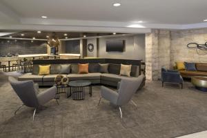 a living room with a couch and chairs and a bar at SpringHill Suites Fort Worth University in Fort Worth