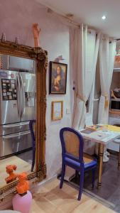 パリにあるCozy Paris Apartmentのキッチン(鏡、テーブル、冷蔵庫付)