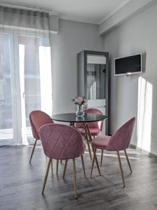 a dining room with a table and two pink chairs at Bardolino Center Apartments in Bardolino