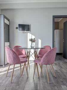 a dining room with a glass table and pink chairs at Bardolino Center Apartments in Bardolino
