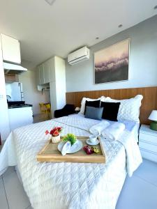 een slaapkamer met een bed met een dienblad met eten erop bij Beira-mar Boa Viagem - Costa Vicentina by Bnb Flex in Recife