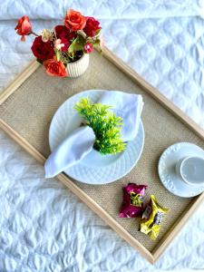 a tray with plates and flowers on a bed at Beira-mar Boa Viagem - Costa Vicentina by Bnb Flex in Recife