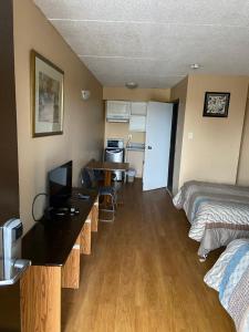 Camera con letto, scrivania e cucina. di Victoria Motel a Kitchener