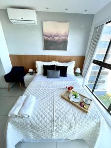 a bedroom with a bed with a tray of food on it at Beira-mar Boa Viagem - Costa Vicentina by Bnb Flex in Recife