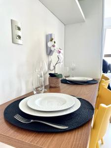 a dining room table with a white plate on it at Beira-mar Boa Viagem - Costa Vicentina by Bnb Flex in Recife
