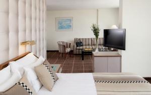 a hotel room with a bed and a flat screen tv at Shalom Jerusalem Hotel in Jerusalem